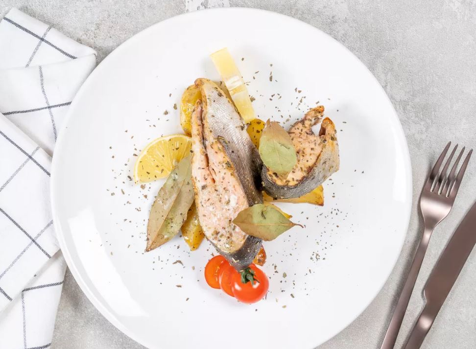 Нежную горбушу выложите на большое сервировочное блюдо. Украсьте дольками лимона и помидорами черри.