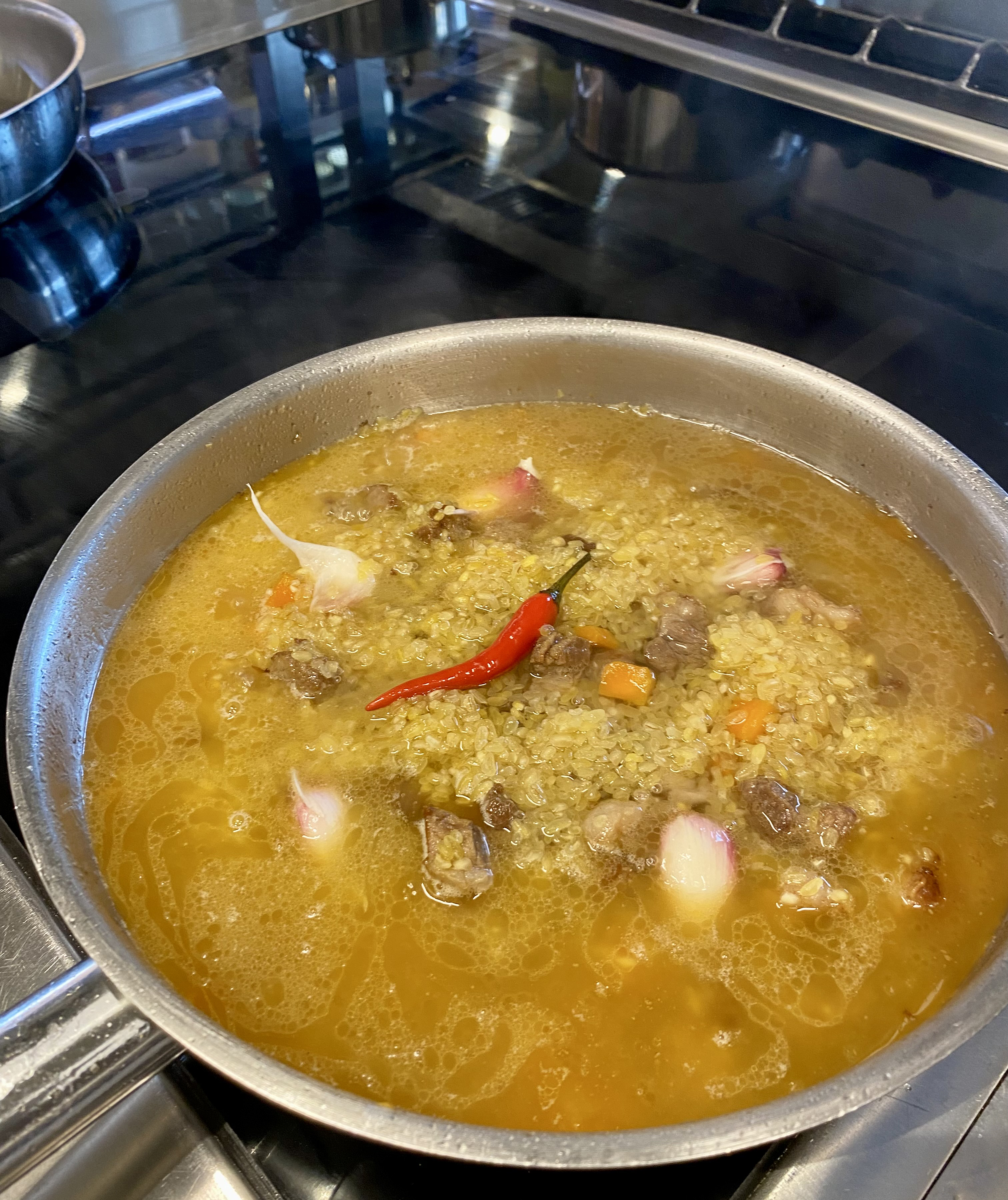 Выкладываем сверху булгур и зубчики чеснока, готовим до полного выпаривания жидкости