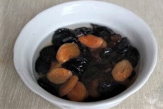 Курагу, чернослив и изюм залить горячей кипячёной водой. Оставить на 10 минут, чтобы сухофрукты размягчились. Затем слить воду. Сухофрукты нарезать кубиками и перемешать с варёным рисом. 