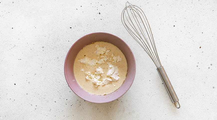Творог протрите через мелкое сито. Добавьте к яичной смеси в миску и тщательно перемешайте все вместе венчиком. Влейте ванильный экстракт. Снова перемешайте.