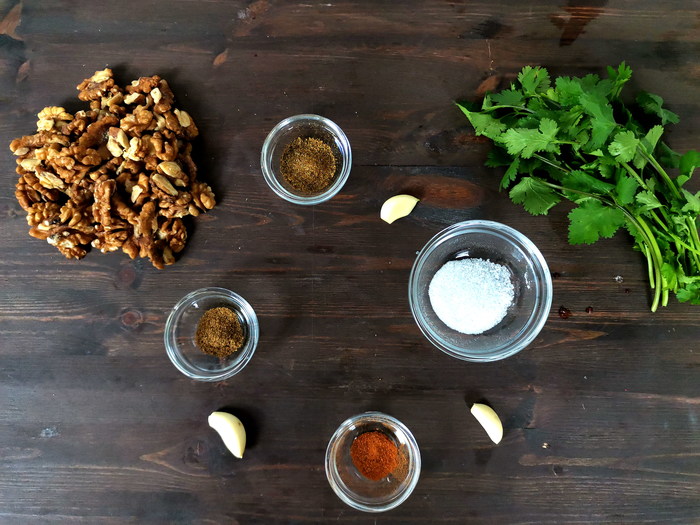 Кинзу мелко нарезать, орехи поджарить на сухой сковороде или прокалить в микроволновке и порубить. Добавить к салату. Положить в салат любимые специи (я добавляла молотый перец и хмели-сунели) и соль. Чеснок очистить и мелко порубить, положить в салат.