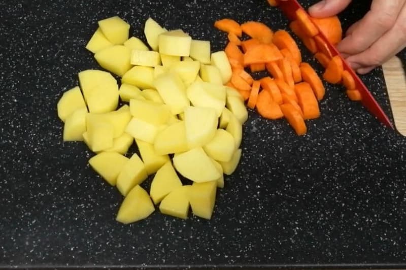 Нарезать картофель кубиками и морковь полукольцами.