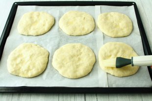 Противень застелите пергаментом. Набирайте тесто одну столовую ложку с большой горочкой. Выкладывайте на расстоянии, тесто при выпекании поднимется. Верх приминая ложкой разровняйте, сформируйте лепёшки, края подровняйте. Делайте толщину лепёшки около 1,5