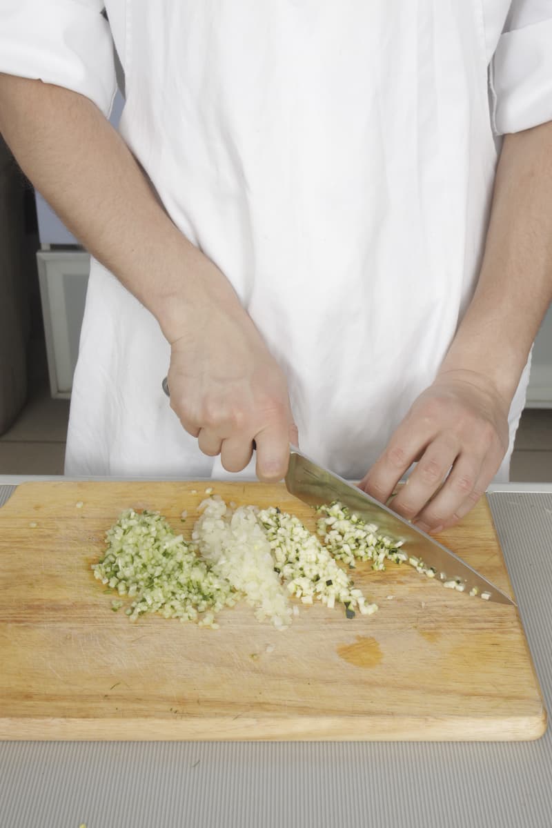 Нарежьте огурец, цукини и лук маленькими кубиками, мелко порубите укроп и сложите в миску. Добавьте сахар и уксус, 1 ст. л. оливкового масла, посолите, поперчите и хорошо перемешайте. Уберите в холодильник на 10 мин.