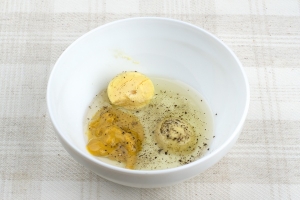 Кладем желток в глубокую посуду, растираем его вилкой, добавляем подсолнечное рафинированное масло, горчицу, соль и перчик черный молотый