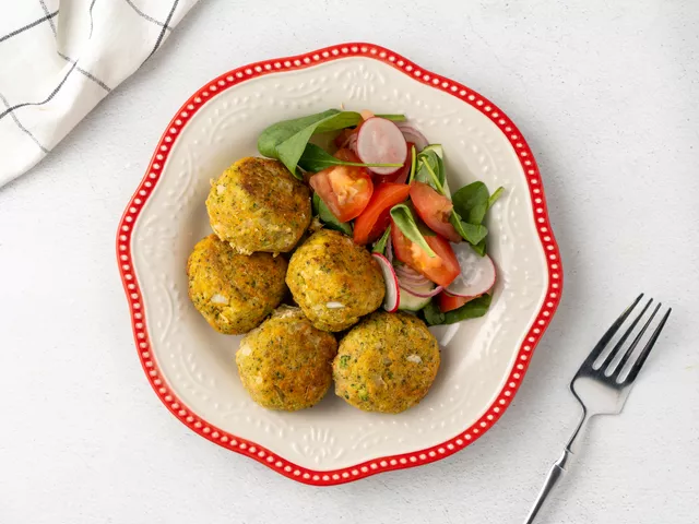 Подайте рыбные фрикадельки с редисом, зеленью и помидорами.