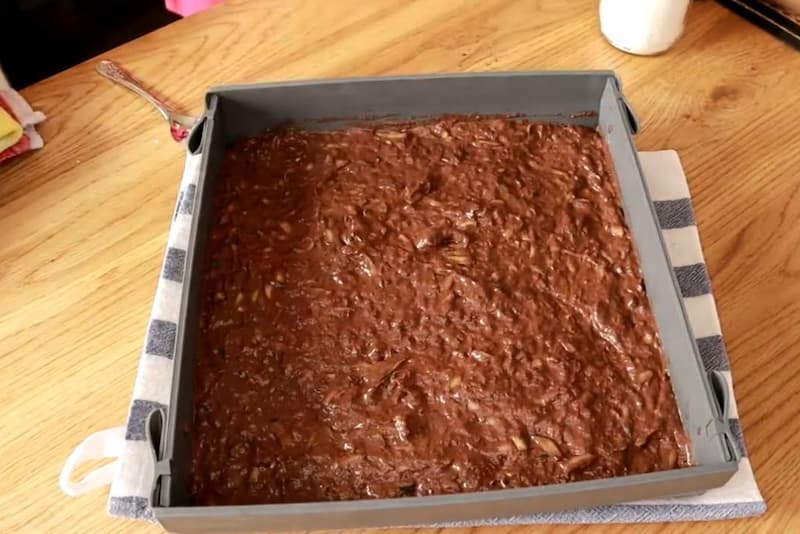Смажьте форму маслом любого сорта и перелейте в нее приготовленное тесто. Разогрейте духовку до 180 градусов и поместите в нее форму. Выпекайте брауни примерно 30-35 минут, проверяя готовность деревянной шпажкой. Она должна выходить сухой из середины пиро