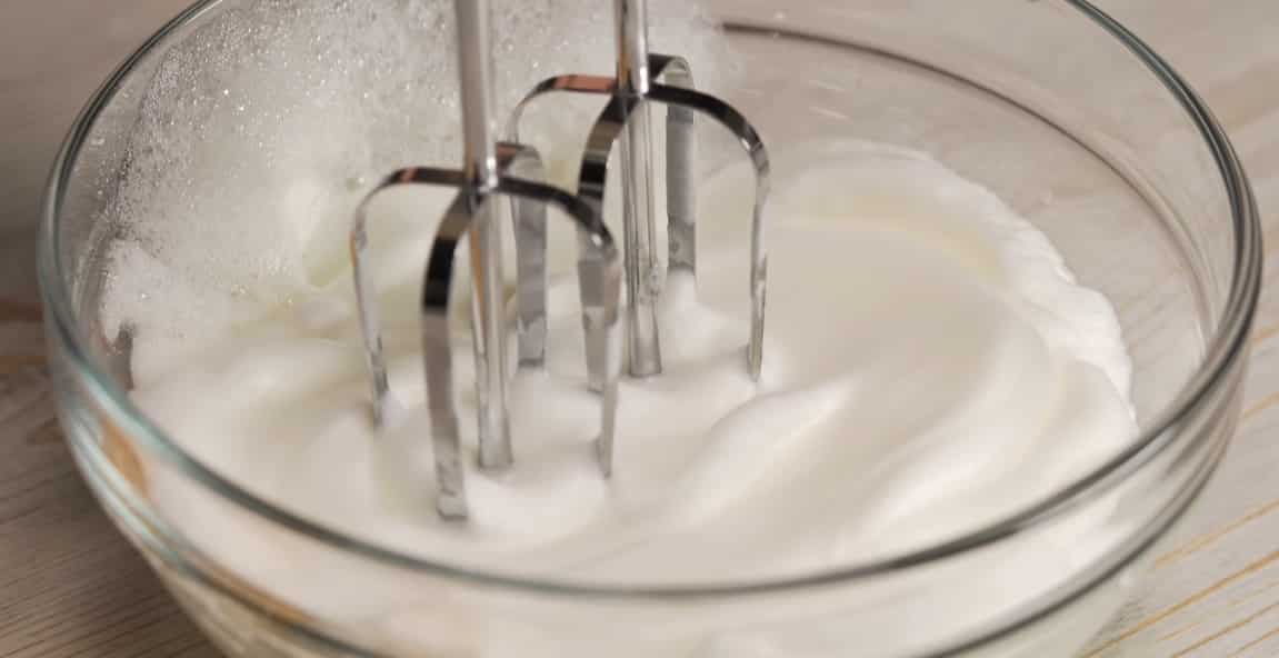В емкость к белкам добавить соль и взбить блендером до состояния плотной пены.