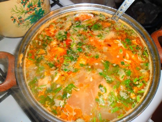 Томаты пропустите через мясорубку и смешайте с бульоном. Спассеруйте лук, добавьте в него нарезанную соломкой морковь, немного обжарьте и выложите в бульон. Муку смешайте с водой и влейте туда же. Заправьте перцем, лавровым листом, измельчённым мясом.