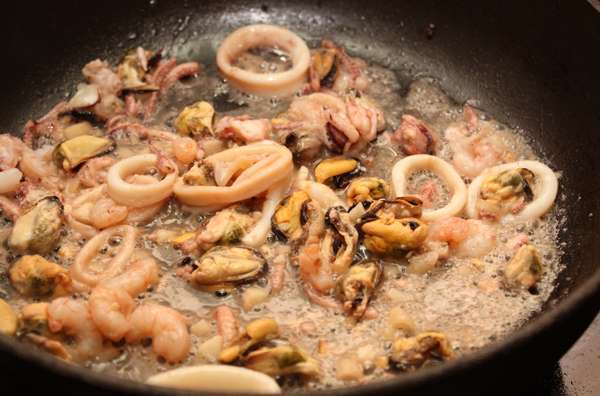 У мидий удалить «бородки», промыть и очистить ракушки. Положить в кастрюлю и поставить на средний огонь. Готовить 6-7 минут, пока они не раскроются. Достать мидии из ракушек, оставить в ракушках несколько штук для украшения. Оставшийся от мидий сок добави