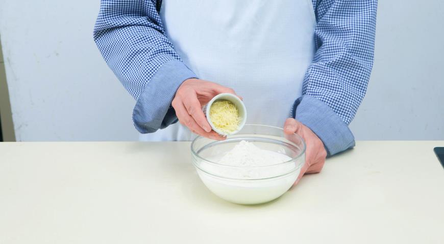 Всыпьте в кефир просеянную муку и тертый сыр, замесите тесто. Добавьте растительное масло, вымесите до однородности. Накройте пленкой и дайте полежать в холодильнике 15–20 мин.