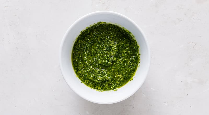 Начните готовить бутерброд с тунцом ПП с намазки. Для нее мелко порубите зелень, сложите в стакан погружного блендера, полейте лимонным соком. Если используете чеснок, раздавите его, очистите, измельчите и добавьте к зелени. Дайте постоять 5 мин. и измель