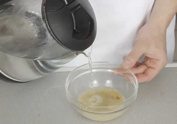 Добавьте к луку с чесноком томатный соус, доведите до кипения. Одновременно залейте сахар с горчичным порошком половиной стакана кипятка, перемешайте до полного растворения. Посолите.