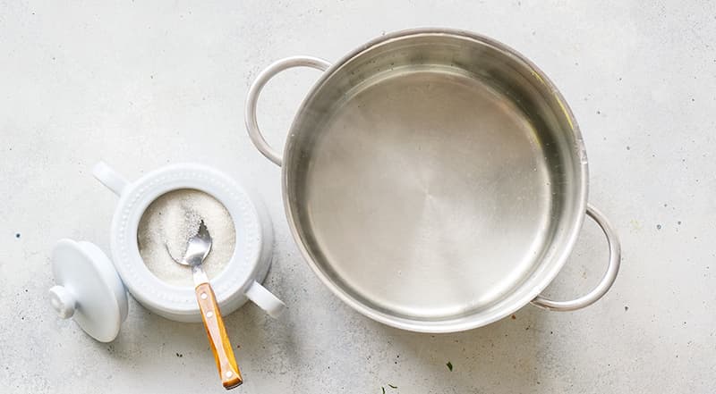 В кастрюлю с водой добавьте сахар, перемешайте, подождите, когда вода вновь закипит. Если используете ароматизаторы, положите их вместе с сахаром.