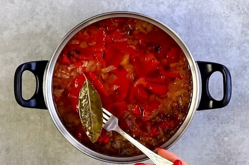 Добавьте нарезанный кусочками перец и обжаренный лук в кастрюлю с овощами и пюрируйте погружным блендером до однородного состояния. Верните кастрюлю на огонь, доведите до кипения, постоянно помешивая, чтобы вкусы объединились. Добавьте мелко нарубленную з