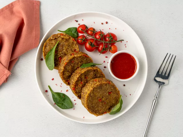 Подайте к биточкам из гречки томатный соус, черри и зелень по вкусу.
