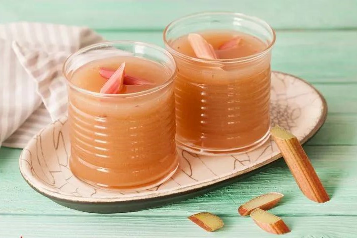 Стебли нужно тщательно вымыть, снять грубую шкурку. Нарезать кубиками или небольшими полосками. Сложить в кастрюлю кусочки и засыпать сахаром. Залить ревеневые кубики холодной питьевой водой и поставить на огонь. Сахар при этом растает, а ревень станет мя