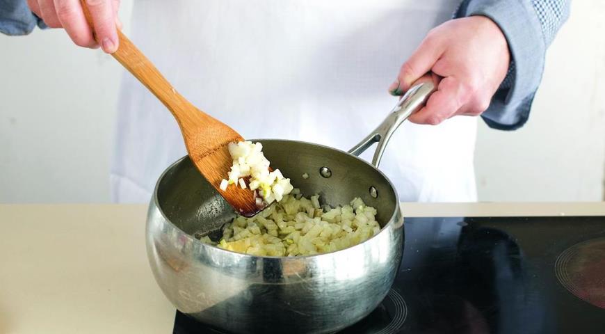 Очистите лук и нарежьте маленькими кубиками. Мелко нарежьте чеснок. Растопите сливочное масло в кастрюле, добавьте лук и чеснок и готовьте на слабом огне, пока лук не станет прозрачным, 5–7 мин.