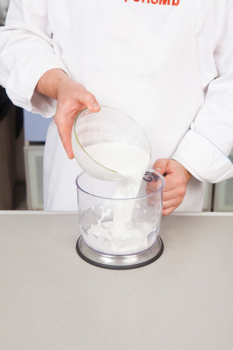 Вылейте кокосовое молоко в чашу блендера и хорошо взбейте, 1 мин.