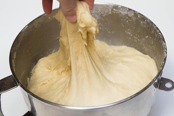 Духовку нагрейте до 180°C. Все сухие ингредиенты, кроме соды, просейте в большую миску и перемешайте. Влейте молоко. Снова перемешайте. Добавьте кокосовое масло, соду и обсушенный изюм. Тщательно вымесите.