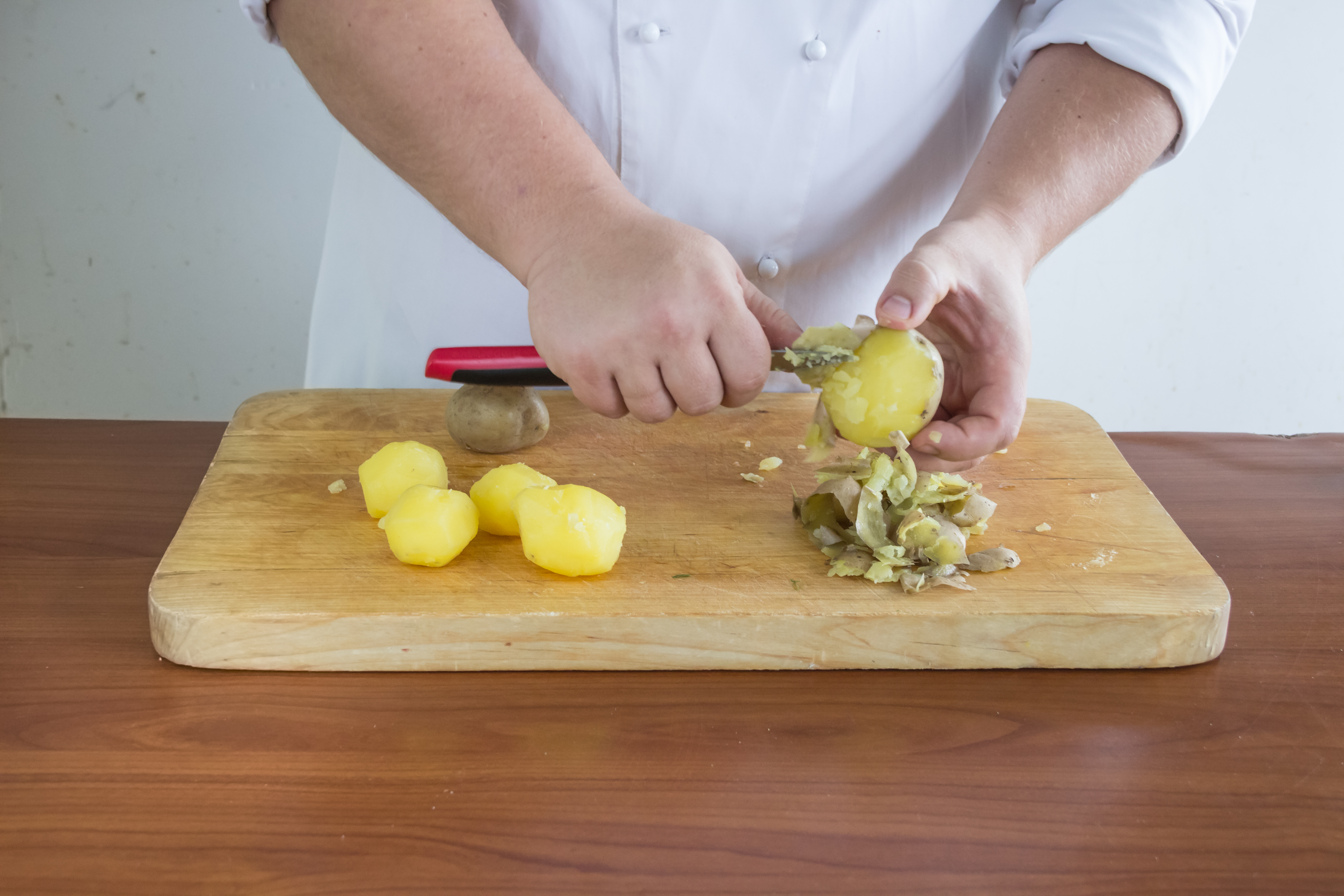 Картофель для оливье сварите в мундире, остудите, очистите, нарежьте кубиками 1х1 см. Сварите яйца вкрутую, остудите под струей холодной воды, очистите и порубите. Два желтка отложите для украшения.