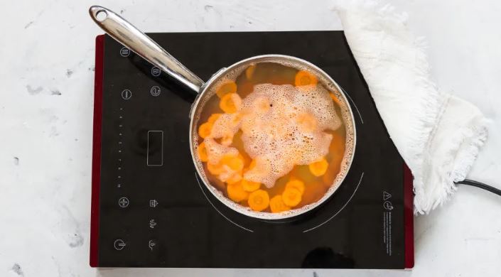 Картофель, морковь, помидоры и лук очистите и нарежьте кружками толщиной 7–8 мм. Несколько веточек зелени отложите для украшения, остальные мелко нарежьте. Положите картофель в подсоленную кипящую воду на 2 мин., добавьте морковь и готовьте еще 2 мин. Акк