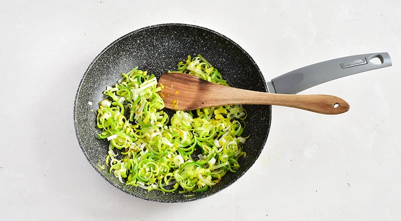 Разрежьте лук-порей вдоль пополам и промойте от песка, который может прятаться между слоями. Тонко нарежьте порей поперек. В большом сотейнике с толстым дном растопите масло, положите порей, посолите, томите на слабом огне, время от времени помешивая, 10 