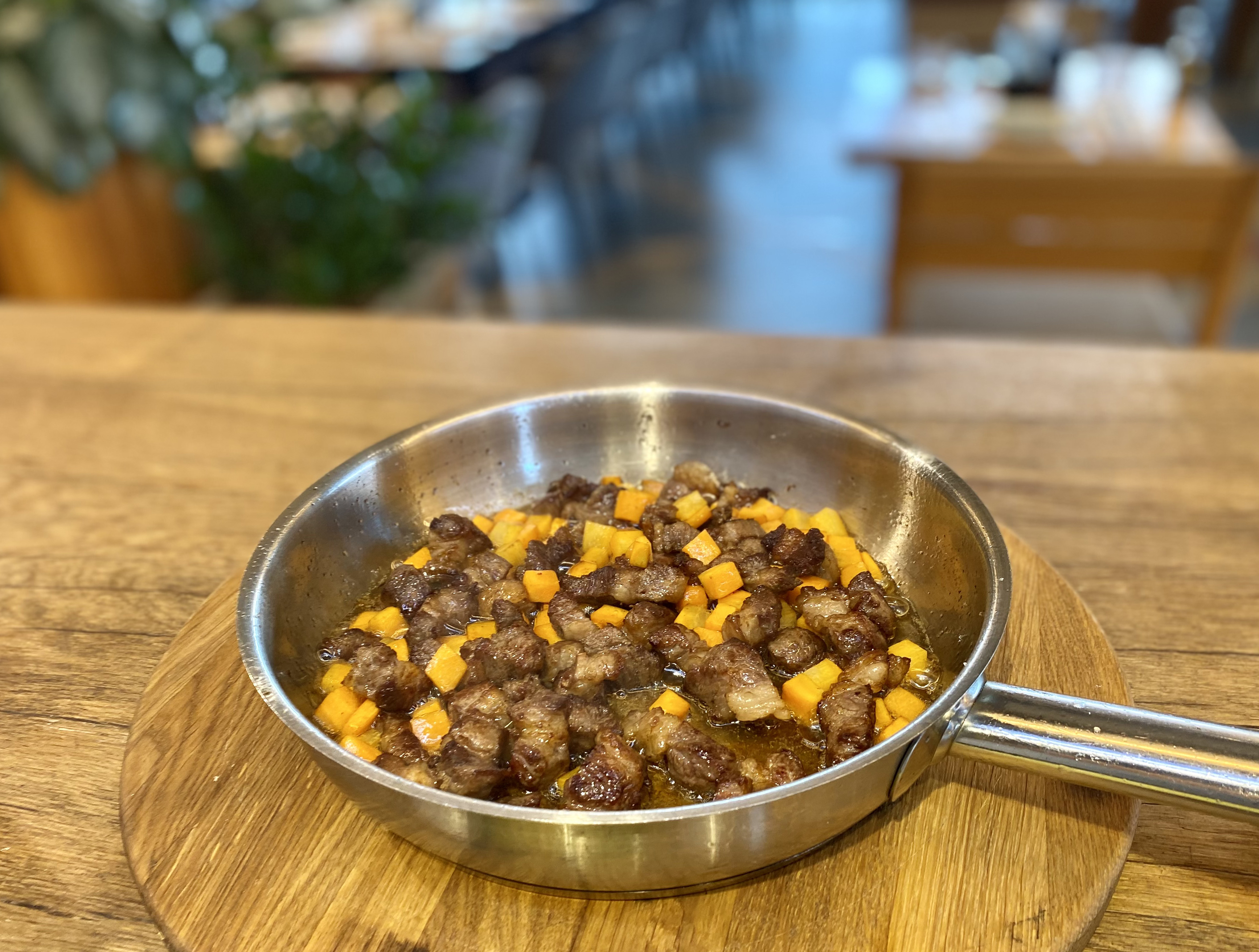 Соединяем обжаренное мясо и нарезанное кубиками морковь, добавляем соль, перец, приправы по вкусу, обжариваем еще минут 10, затем заливаем кипящей водой и тушим до готовности мяса