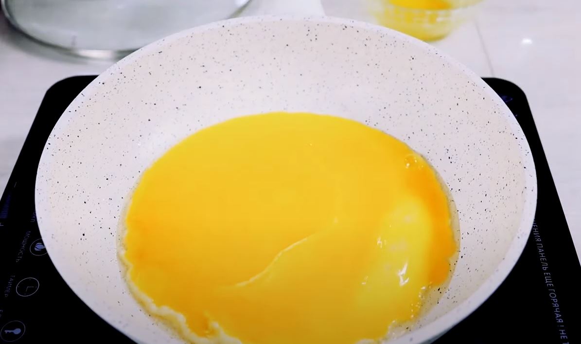 На сковороде разогреть масло и вылить туда желтки, равномерно заполняя всю поверхность. На хорошо прогретой сковороде желтки должны схватиться практически сразу. Если этого не произошло, то просто подержите еще 1–2 минуты, чтобы низ загустел, а верх остал