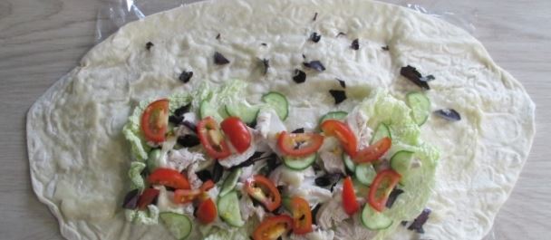 Далее на капусту выкладывайте курицу, помидоры и огурцы. Можно добавить немного соуса на курицу.