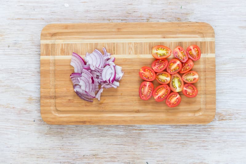 Помидоры черри вымойте и обсушите. Разрежьте на половинки. Лук очистите и нарежьте тонкими полукольцами. Соедините все ингредиенты в большой миске и перемешайте.