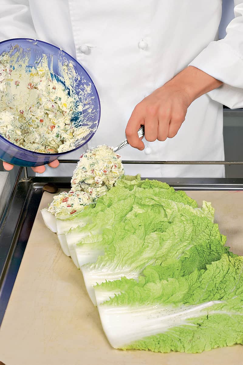 Капусту вымыть, отрезать донце. Положить кочан на разделочную доску и движением от себя раскатать его примерно до середины так, чтобы не нарушить порядок листьев. Сердцевину кочана удалить и использовать для приготовления других блюд. На край листьев выло