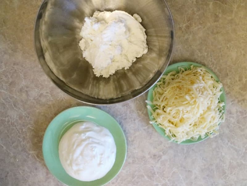 Пока расстаивается тесто готовим начинку. Творог перетираем через сито или при помощи блендера. Протертый творог смешиваем со сметаной, добавляем соль. Сыр натираем на крупной терке.