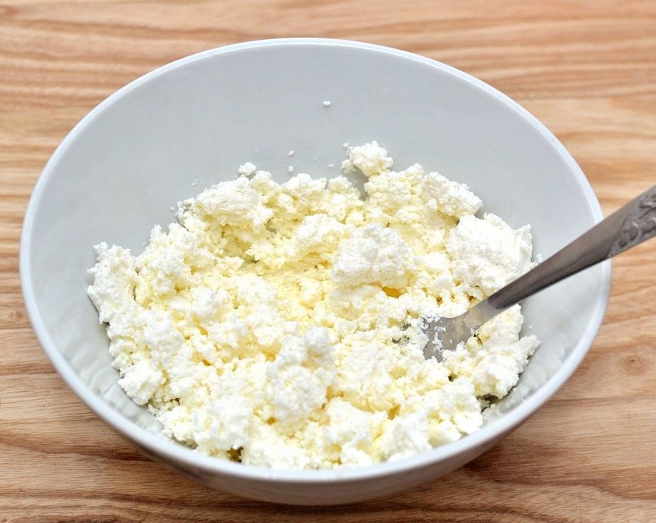 В глубокой миске разомните творог вилкой, чтобы не оставалось комочков, пробивать блендером не надо. Добавьте взбитые белки с сахаром. Перемешайте всё вилкой. 