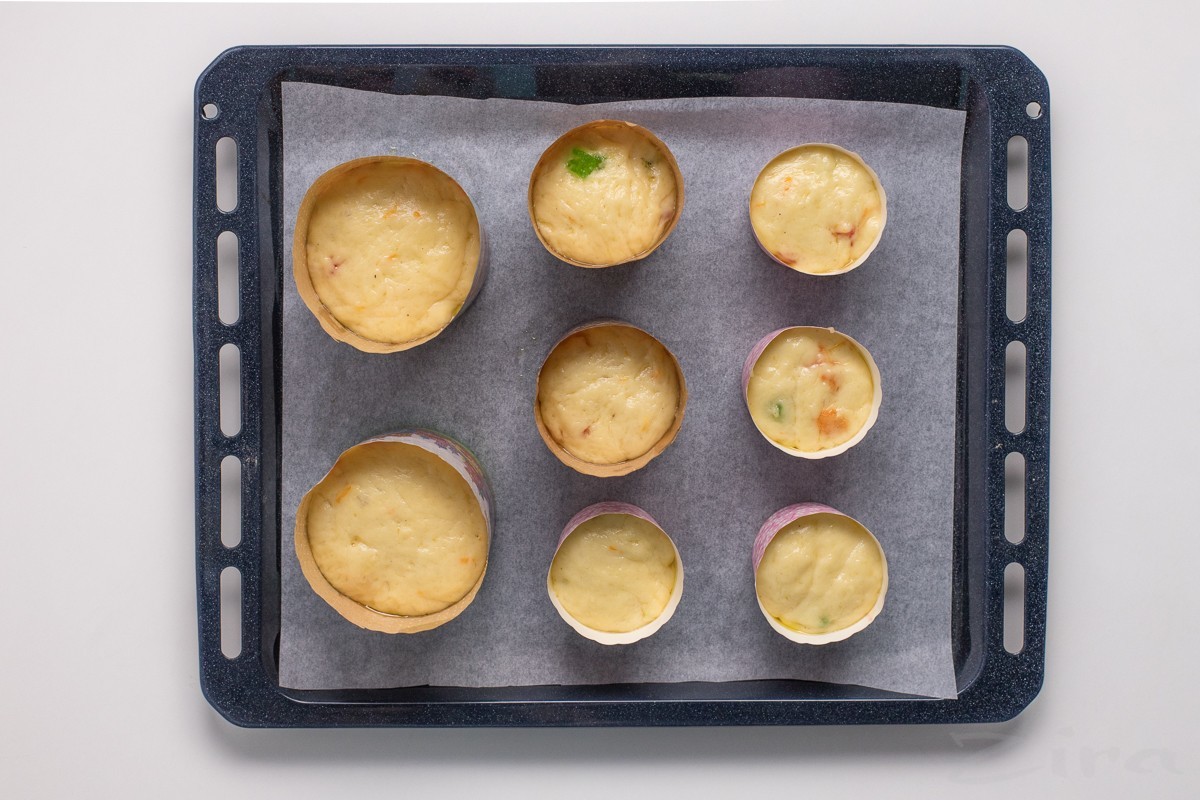 Получившееся тесто сразу же разложите по подготовленным формам. Наполняйте их не более чем на 3/4 высоты: такой запас необходим для подъема куличей в процессе выпекания.