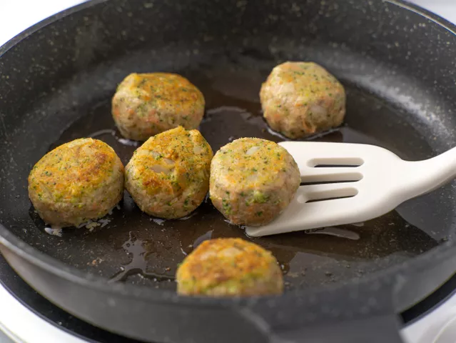Налейте масло в сковороду, разогрейте его на сильном огне. Выложите фрикадельки в горячее масло. Обжарьте их со всех сторон, периодически переворачивая, 6-7 минут до золотистой корочки.