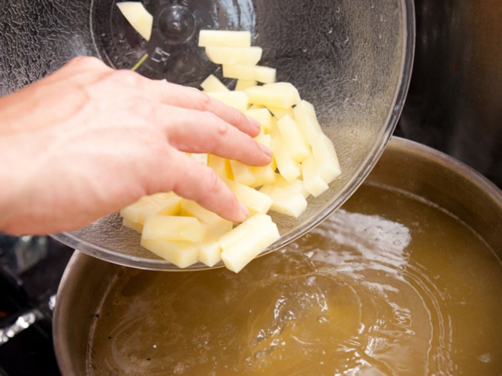 Увеличить нагрев под бульоном и добавить в бульон картофель кубиками. Дать закипеть, снять картофельную пену и добавить булгур. Варить минут 15, до готовности картофеля и почти до готовности крупы.