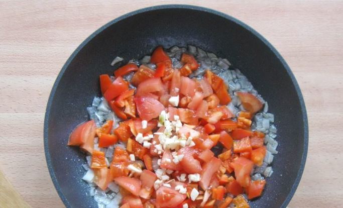 Нарежьте помидоры, лук и перец мелкими кубиками и обжарьте на сухой сковороде, либо с добавлением оливкового масла на медленном огне. Выдавите чеснок в смесь. Жарьте до того момента, пока все ингредиенты размягчатся. Добавьте немного воды, чтобы смесь ста