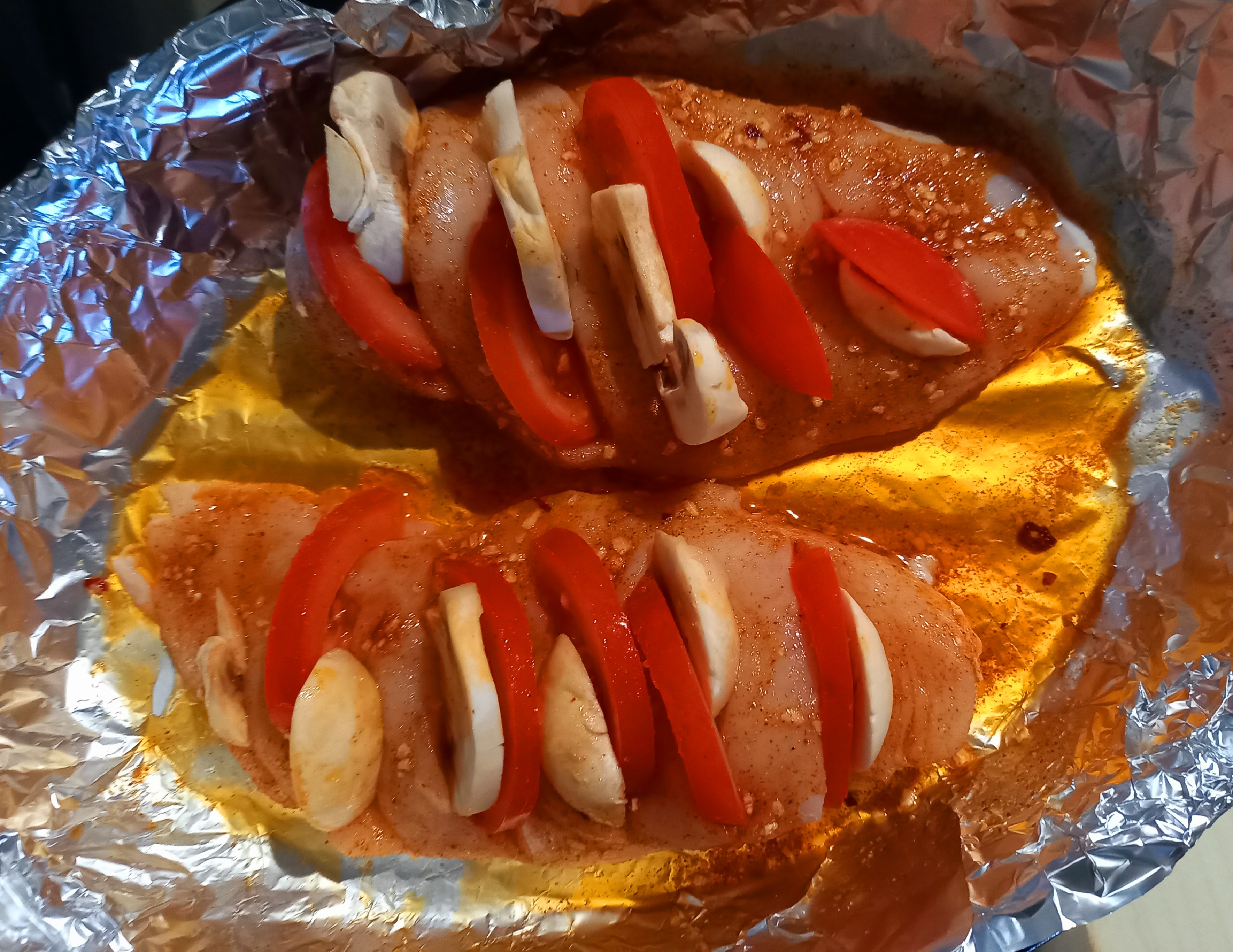 Обмазываем грудку со всех сторон, не забываем и о кармашках. Выкладываем мясо в форму для запекания и заполняем кармашки: кусочек сыра + кусочек нарезанного шампиньона + кусочек нарезанного полукольцами помидора.