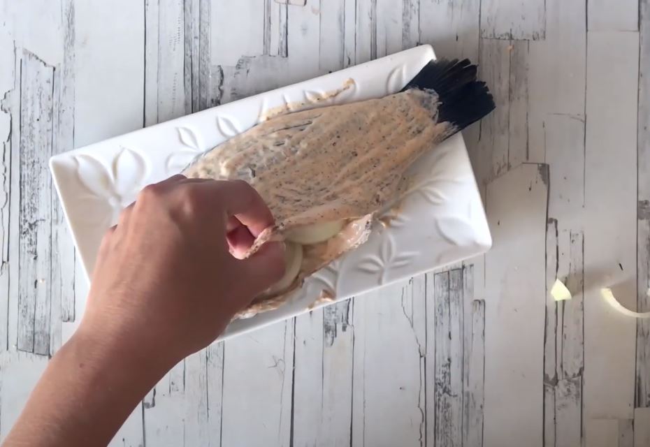 Хорошо промазать рыбу соусом как внутри, так и снаружи. Нафаршировать луком.