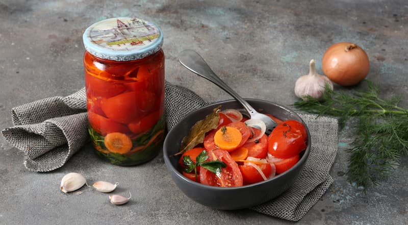 Достаньте, влейте в каждую банку с помидорами столовый уксус и сразу же закатайте крышками. Переверните на сложенное вдвое полотенце дном и дайте полностью остыть при комнатной температуре. Если желаете, замените часть помидоров свежими огурцами, нареза