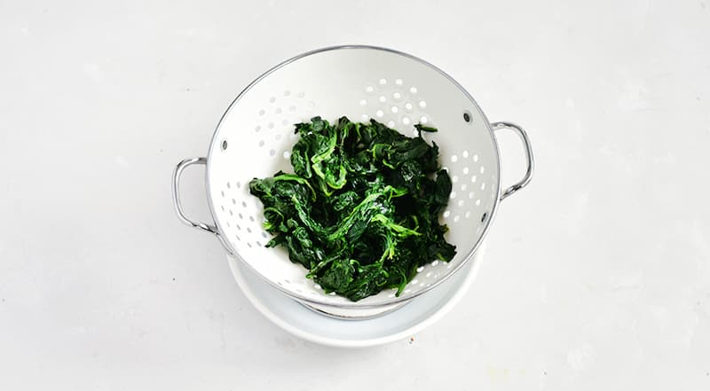 Заранее разморозьте шпинат, уложив его в дуршлаг, стоящий в миске. Жидкость, которая стекла в миску, не понадобится.