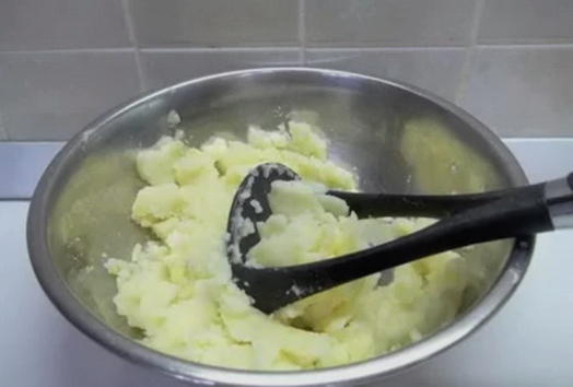 Когда лук уже готов, добавляем его в слегка остывшее картофельное пюре. Отправляем туда же яйцо, соль, молотый перец и чеснок (пропускаем через пресс или мелко рубим). Вымешиваем массу вилкой до однородности. Получится достаточно плотное картофельное тест