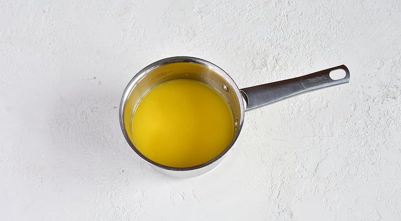 Желатин насыпьте в ковшик и залейте апельсиновым соком. Оставьте на 15 минут. Затем поставьте на слабый огонь и, помешивая, нагревайте, не доводя до кипения, до тех пор, пока желатин не растворится полностью.