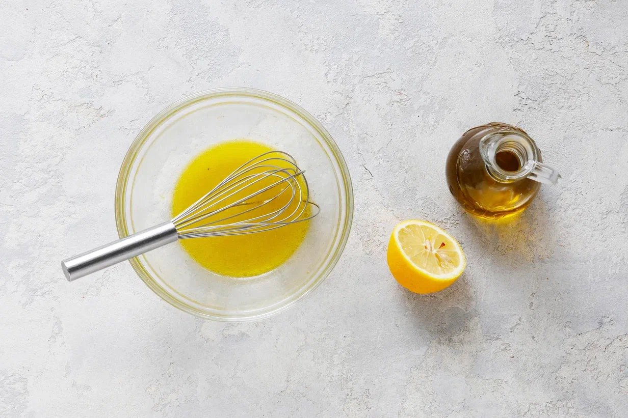 Для соуса оливковое масло слегка взбейте с лимонным соком. Добавьте тертую цедру и перемешайте. Полейте получившимся соусом ингредиенты салата и перемешайте. Уложите в салатник и подайте на стол.