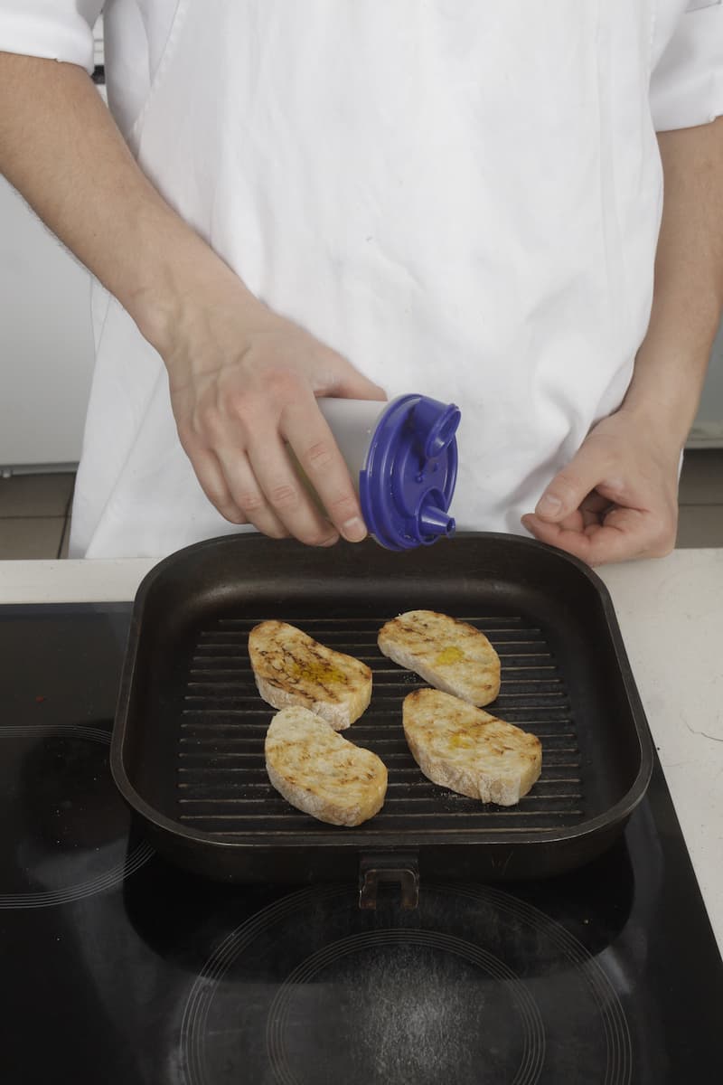 Подрумяньте кусочки чиабатты на гриле или в духовке, сбрызните оливковым маслом и натрите чесноком. Разложите начинку на хлеб и подавайте.