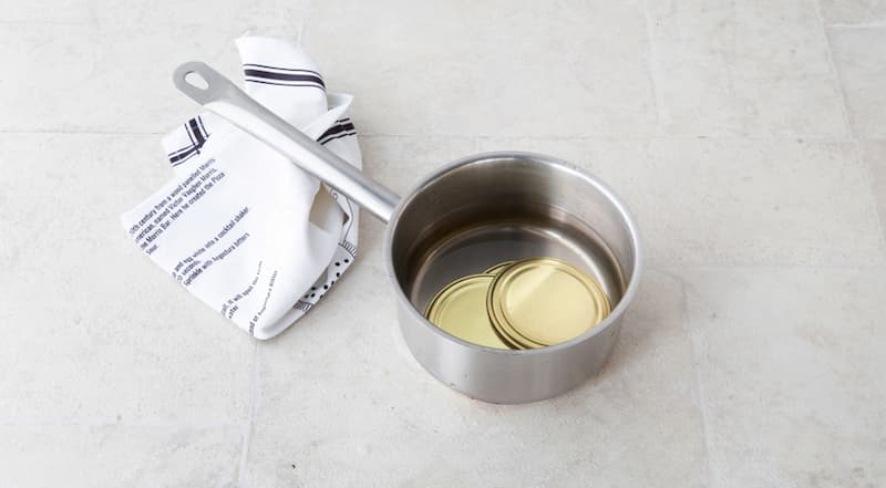 Крышки положите в сотейник, залейте водой, поставьте на огонь и доведите до кипения, кипятите 3 мин. и снимите с огня. Оставьте крышки в горячей воде до использования.