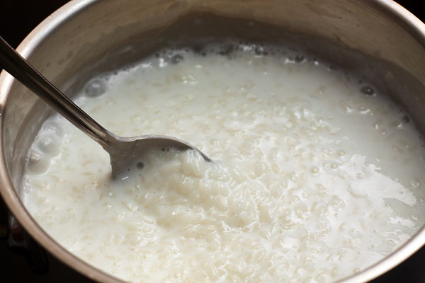 Всыпать в масло промытый рис.Влить кипящее молоко. Рис потомить немного в молоке.Добавить цедру и щепотку соли.