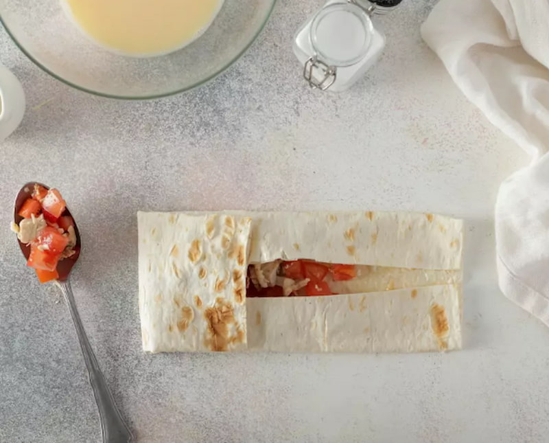 На каждую заготовку выложите 1–2 ст. л. начинки и заверните в небольшие конвертики или рулетики.