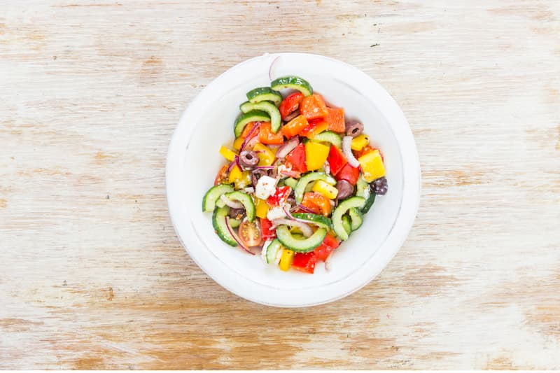 Брынзу нарежьте кубиками со стороной 1.5 см. Оливки освободите от косточек. Разложите брынзу и оливки на салат, перемешайте. Оставьте при комнатной температуре на 30 минут, затем подавайте.